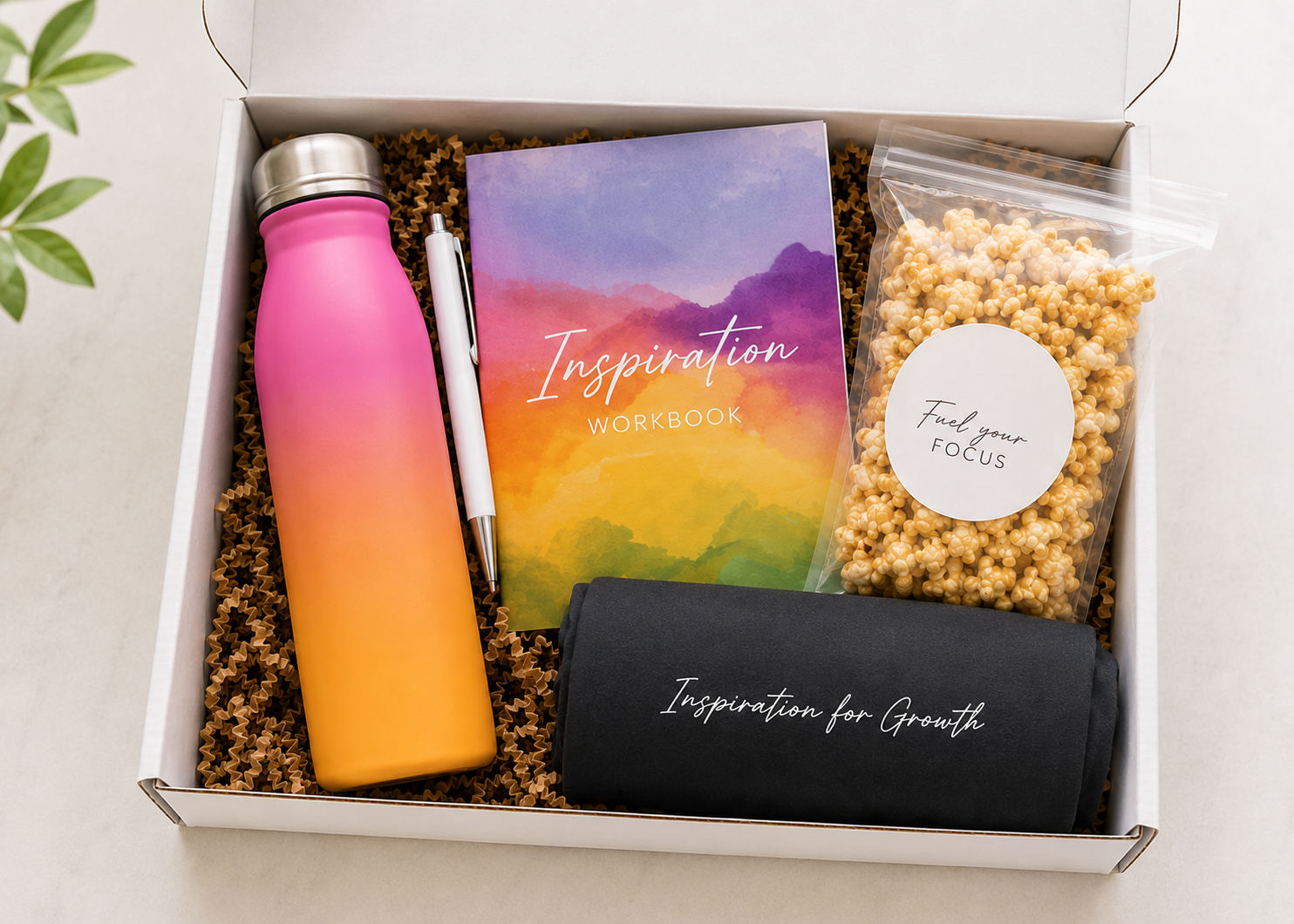 Curated client welcome box with workbook water bottle branded merchandise and snack