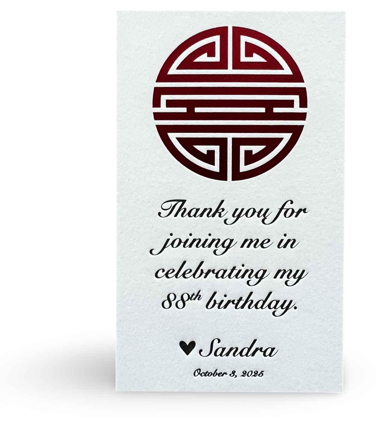 Letterpress bookmark with a red foil emblem and black letterpress type