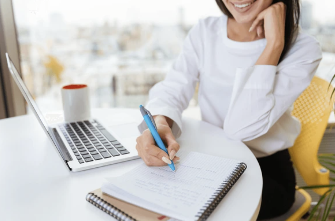 Course creator working with laptop and printed workbook