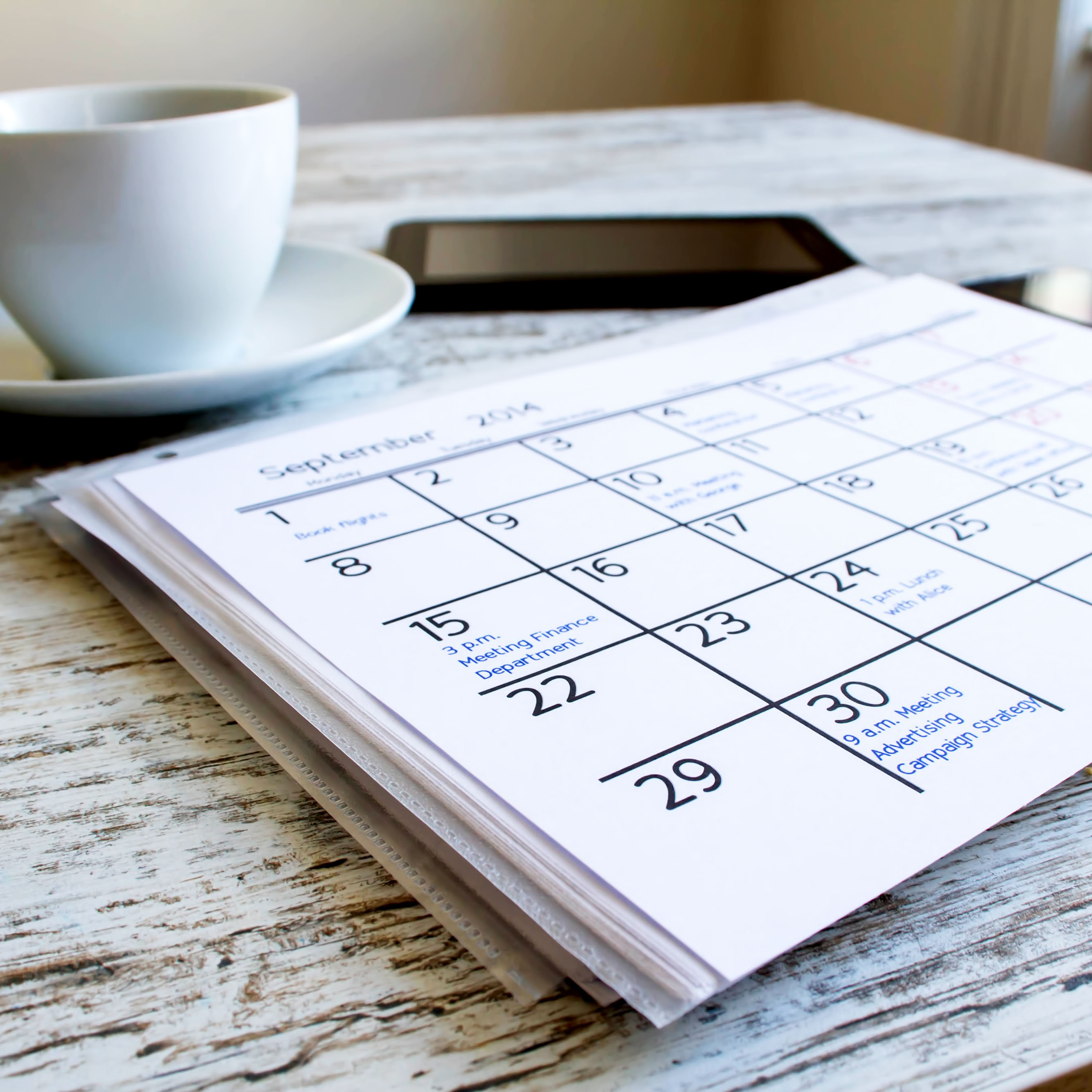 A calendar and cup of coffee